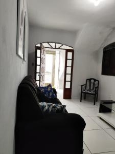 ein Wohnzimmer mit einem schwarzen Sofa und einem Fenster in der Unterkunft Casa Festival de inverno Garanhuns in Garanhuns