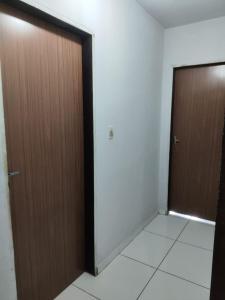 zwei braune Türen in einem Raum mit weißen Fliesen in der Unterkunft Casa Festival de inverno Garanhuns in Garanhuns