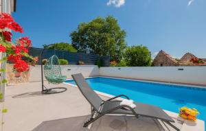 a patio with two chairs and a swimming pool at Cozy Home In Dobrince in Bartulovici +36 photos
