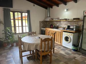 eine Küche mit Tisch, Herd und Waschmaschine in der Unterkunft Jireh in Esquel