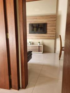 ein Wohnzimmer mit einem TV und ein Zimmer mit einem Tisch in der Unterkunft Casa do Cristiano no bairro Rosário in Ouro Preto