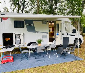 a white caravan with a table and chairs in front of it at Vanlodge in Varneil