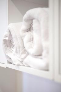 a stack of towels on a shelf in a bathroom at 2 Pièces Cosy - Mairie Des Lilas in Les Lilas