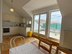 a kitchen with white cabinets and a large window at Luxury Penthouse near Metro, Train Station and 15 mins Center in Vienna +12 photos