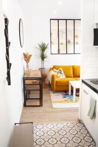 a living room with a yellow couch and a table at 2 Pièces Cosy - Mairie Des Lilas in Les Lilas