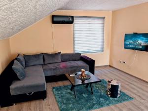 a living room with a couch and a table at Apartman Popović in Niš