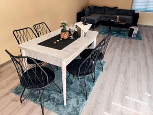 a dining table and chairs in a living room at Apartman Popović in Niš