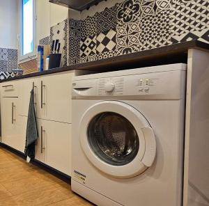 een wasmachine in een keuken met een aanrecht bij Appartement Paris Mangin in Asnières-sur-Seine
