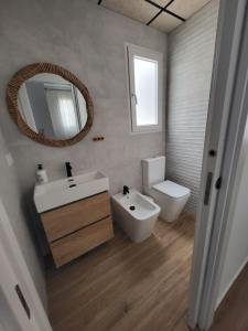 a bathroom with a sink and a toilet and a mirror at Apartamento Coral in Peñíscola +35 photos