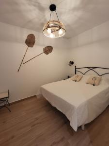 a bedroom with a bed and a chandelier at Apartamento Coral in Peñíscola
