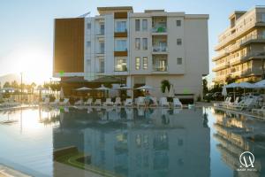 a hotel swimming pool with chairs and a building at Maor Hotel in Vlorë