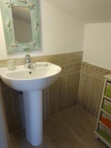 a bathroom with a white sink and a mirror at Holiday House La Rosa dei Venti in Palau +14 photos