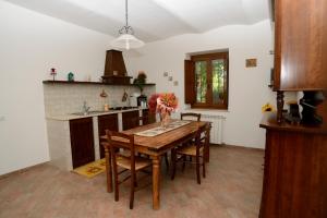 a kitchen with a wooden table and some chairs at L'Antico Casale Di Sandro in Acquasparta