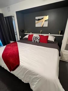 a bedroom with a large white bed with red pillows at Modern Dream at Fairmont in Fairmont Hot Springs