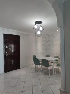 une salle à manger avec une table, des chaises et un lustre dans l'établissement Appartement de standing, à Casablanca