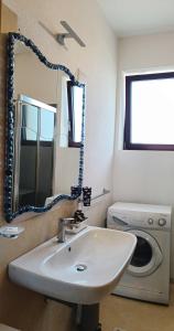 un bagno con lavandino e lavatrice di Dody's Home a Otranto