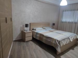 une chambre avec un lit, une commode et une fenêtre dans l'établissement Appartement de standing, à Casablanca