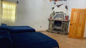 a living room with two beds and a fireplace at Cabaña en bosque de Mazamitla,Jalisco in Mazamitla