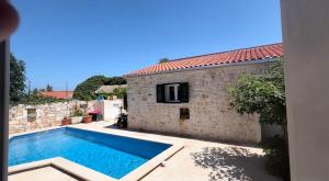 a villa with a swimming pool next to a building at Villa Rosa, Dracevica 46a, Brac in Dračevica