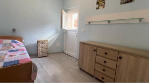 a bedroom with a bed and a dresser and a window at Villa Rosa, Dracevica 46a, Brac in Dračevica