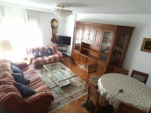 un soggiorno con un divano e un tavolo di Piso 3 habitaciones en Grado a Grado