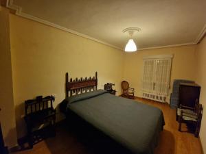 una camera da letto con un letto e una TV a schermo piatto di Piso 3 habitaciones en Grado a Grado