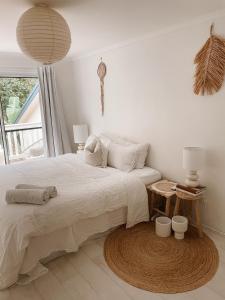 una camera da letto bianca con un letto e un tavolo di Cosy Home Byron Bay a Byron Bay
