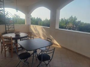 un patio con 2 mesas y sillas y una ventana en Vista mare a Trabia Serra Scirocco, en Mandra Capreria