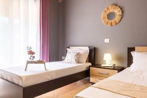 a bedroom with two beds and a mirror on the wall at Potam'Sea Bliss 33- Beach Front, Sun Beds & Parking in Himare