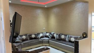a living room with a couch and a tv at Residence wassim in Ras El Ma