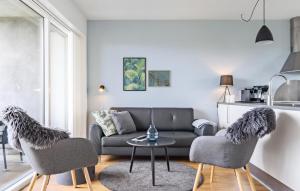 スナーヴィグにあるStunning Apartment In Ringkøbingのソファと椅子2脚とテーブルのあるリビングルーム
