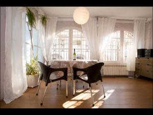 comedor con mesa, sillas y ventanas en Holiday home Anexa, en Masnou