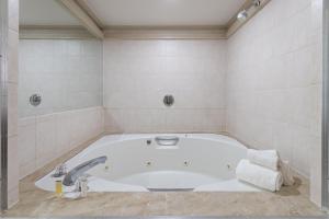 una vasca bianca in bagno con lavandino di Inn at Atlantic City Hotel & Banquet ad Absecon