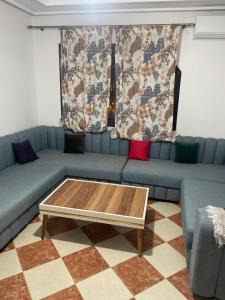 een woonkamer met een blauwe bank en een salontafel bij Appart malabata in Tanger
