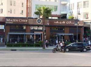 een man op een motor voor een restaurant bij Appart malabata in Tanger