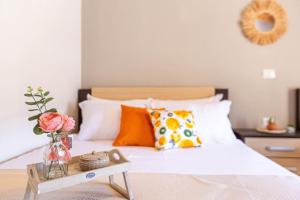 a bed with orange and white pillows and a table at Potam'Sea Bliss 35- Beach Front, Sun Beds & Parking in Himare