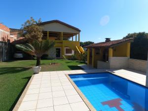 a house with a swimming pool in a yard at Casa de Temporada Meaipe in Guarapari
