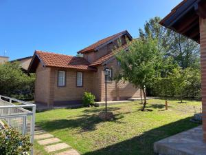 a brick house with a tree in the yard at Cabañas Abril in Merlo