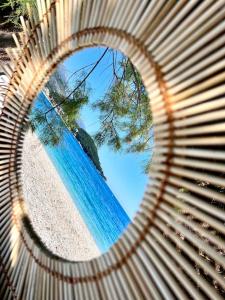 une vue sur l'océan à travers un banc en bois dans l'établissement Potam'Sea Bliss 38- Beach Front, Sun Beds & Parking, à Himarë