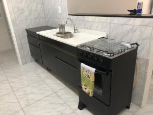 a kitchen with a black stove and a sink at Apartamento Laguna in Laguna