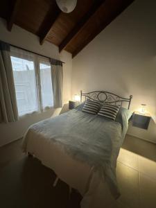 a bedroom with a bed with two pillows and a window at Casa Arroyo - Esquel in Esquel