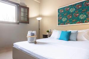 a bedroom with a large white bed with blue pillows at Color Villa - South Paradise 2 in Himare