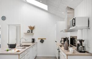 a white kitchen with a sink and a microwave at 4 Bedroom Lovely Home In Hals in Hals