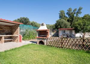 a brick oven in a yard next to a fence at Adam House-Castle view in Toroni