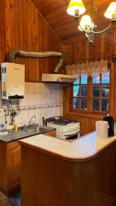 a kitchen with a sink and a stove top oven at Cabaña en Villa Los Leones in Pinto