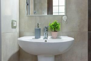 a white sink in a bathroom with a plant on it at Color Villa - South Paradise 6 in Himare +26 photos
