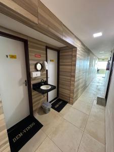 een gang met een badkamer met wastafel en spiegel bij Pousada Grandmar, Maragogi in Maragogi +72 foto's