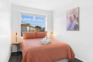 a bedroom with a bed with two stuffed animals on it at Idyllic family escape, Close to the beach and Mount in Mount Maunganui