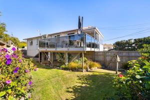 a house with a balcony and a fence at Idyllic family escape, Close to the beach and Mount in Mount Maunganui