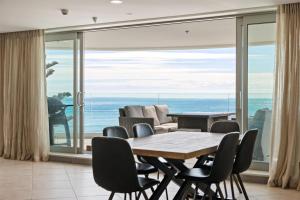a dining room with a view of the ocean at Oceanside Bliss - Absolute Beachfront - Uninterrupted Ocean Views with Pool in Mount Maunganui